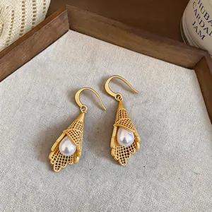Detailed macro view of French light luxury gold earrings with hollow mesh design