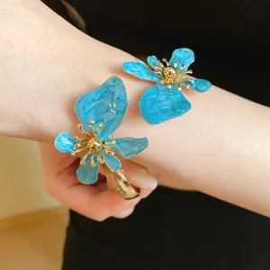 Detaillierte Nahaufnahme einer blauen Emaille-Blumen-Armspange mit Goldbeschichtung