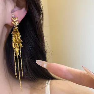 Detailed view of elegant vintage gold wheat spike tassel earrings with sparkling zircons