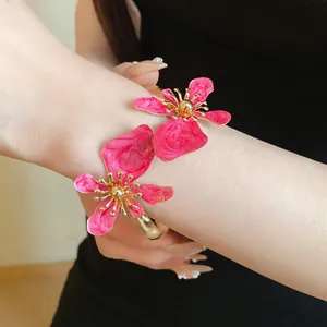 Detaillierte Nahaufnahme eines eleganten rosa Emaille-Blumenarmbands mit Gold-Finish