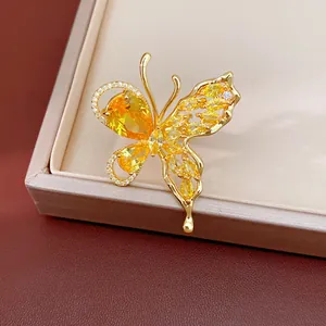 Close-up macro view of a gold plated butterfly earring with vibrant yellow zircon crystals