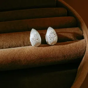 Detailed macro view of silver frosted water-drop earrings with zircon star inlay