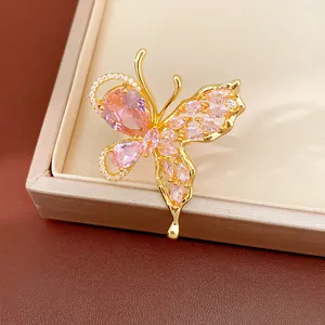 Close-up detail of a butterfly earring with pink zircons and gold plating.