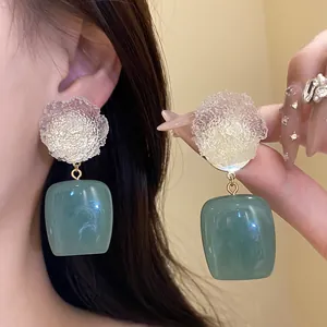 Detailed macro shot of vintage resin flower earrings with green square pendant drops