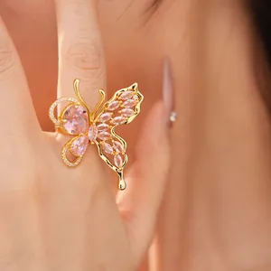 Detailed view of an elegant gold-plated butterfly ring with sparkling pink stones.