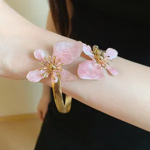 Detailansicht eines eleganten Armreifs mit zwei rosa Emaille-Blumen-Details