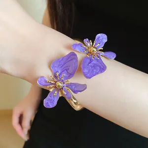 Detailansicht eines eleganten lila Emaille Blumen Armreifs an einem weiblichen Arm