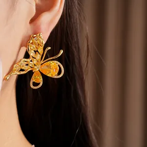 Close-up detail of a gold-plated butterfly stud earring set with bright yellow zircons