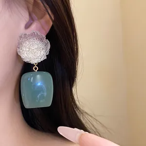 Detailed close-up showing retro resin flower and green square drop earrings worn by a model