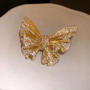 Close-up of 18k gold plated butterfly brooch with shimmering pavé set crystals