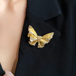 Detailed close-up of an elegant 18k gold plated butterfly brooch pinned on a black blazer