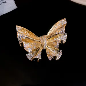 Close-up detail of a 18k gold plated butterfly brooch with sparkling crystals.