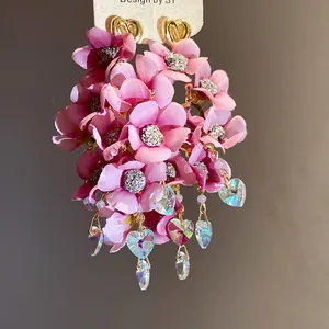 Exquisite close-up of pink fabric flower tassel earrings with iridescent heart charms