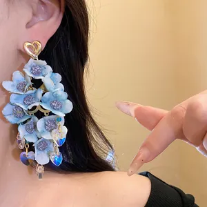 Detailed view of elegant light blue fabric flower tassel earrings with heart pendants