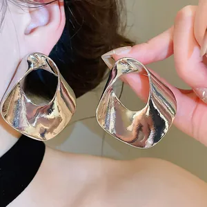 Detail shot of large silver geometric hollow earrings with irregular hammered texture