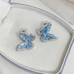 Elegant light blue zircon butterfly stud earrings presented in a luxury jewelry gift box