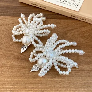 Elegant handmade pearl flower hair clips for women on a vintage wooden background