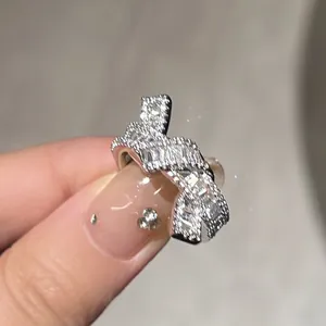 Primer plano de un anillo de nudo plateado con brillantes circonitas baguette