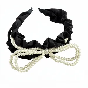 Elegant black ruffled fabric headband featuring a large multi-strand pearl-beaded bow