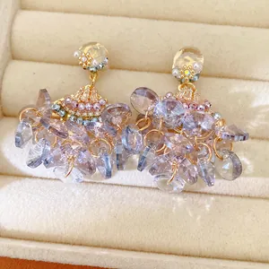 Detailed macro shot of fan-shaped crystal tassel earrings with lavender glass drops.