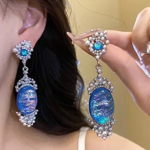 Exquisite vintage earrings featuring blue iridescent oval stones with elegant white pearl beads