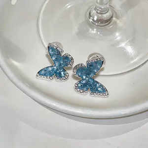 Close-up of elegant gradient blue butterfly clip-on earrings with sparkling zirconia stones