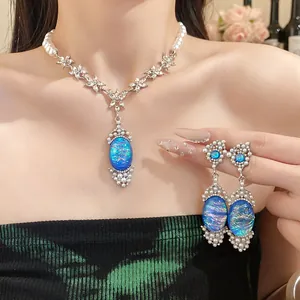 Elegant pearl necklace set with shimmering blue oval pendants and matching earrings