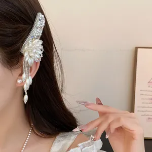Close-up view of an elegant pearl flower hair clip with tassels worn by a model