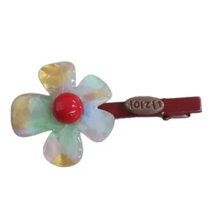 Colorful resin flower hair clip with iridescent petals and red center bead.