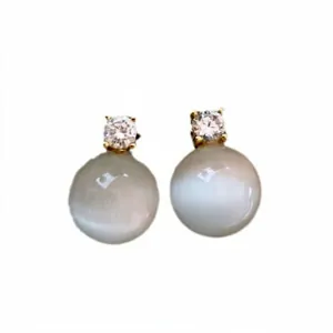 Elegant silver needle stud earrings with round cat's eye stones and cubic zirconia.