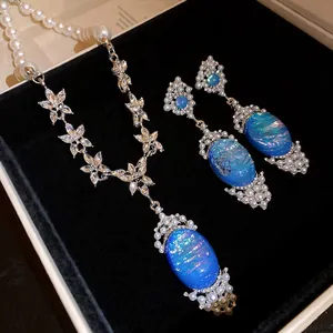 Luxurious pearl and rhinestone jewelry set featuring blue iridescent oval pendants