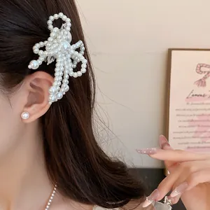 Detailed close-up of an elegant pearl flower hair clip worn by a model for styling