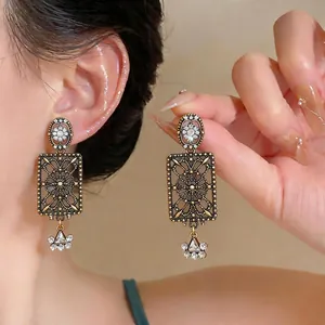 Orecchini vintage in stile palazzo in lega con motivi quadrati traforati e strass scintillanti.