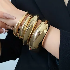 Set di bracciali aperti dorati irregolari e spessi con finitura liscia lucida