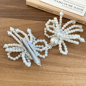 Detailed back view of handmade pearl flower tassel hair clip with silver metal base
