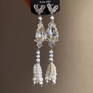 Vintage silver needle earrings featuring teardrop crystals and elegant pearl tassels