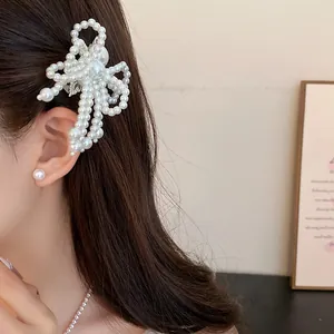 Close-up of elegant white pearl bow hair clip worn by a model for a sweet and stylish look