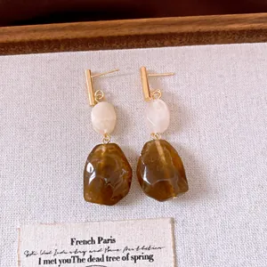 Detailaufnahme französischer Vintage-Resin-Ohrringe mit olivgrünen Anhängern.