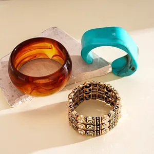 Close-up of vintage acrylic geometric bangles and triple-layered rhinestone elastic bracelet