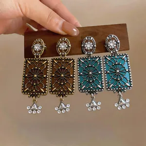 Primo piano di orecchini quadrati in stile palazzo vintage con strass e dettagli filigrana