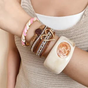 Detailed view of multilayer leather heart bracelet and wide cream resin bangle