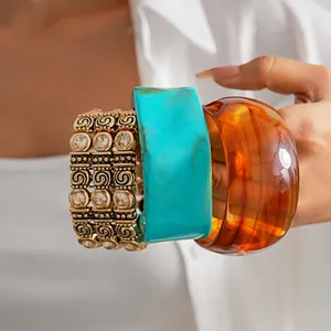 Detailed view of layered rhinestone bracelet and vibrant acrylic geometric bangles.