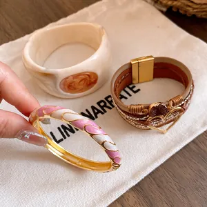 Close-up of retro Maillard style resin bangle and multi-layer heart leather bracelet