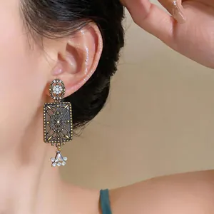 Primo piano di orecchini quadrati vintage in lega con delicati dettagli in strass scintillanti