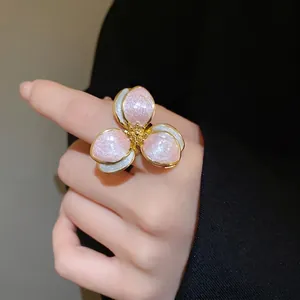 Elegant vintage metal flower ring featuring pink glitter enamel petals on a gold band