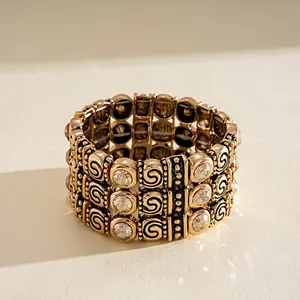 Detailed view of a bohemian three-row vintage gold stretch bracelet with rhinestones