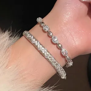 Close-up detail of a minimalist silver zircon oval link bracelet on a wrist