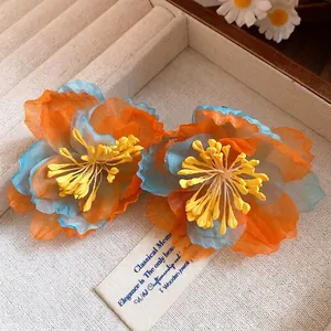 Bohemian chiffon flower earrings in orange and blue for vacation style.
