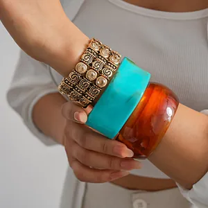 Detail view of chunky acrylic bangles and a vintage rhinestone elastic bracelet