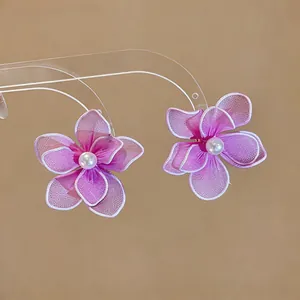Close-up detail view of pink mesh flower stud earrings with elegant pearl center